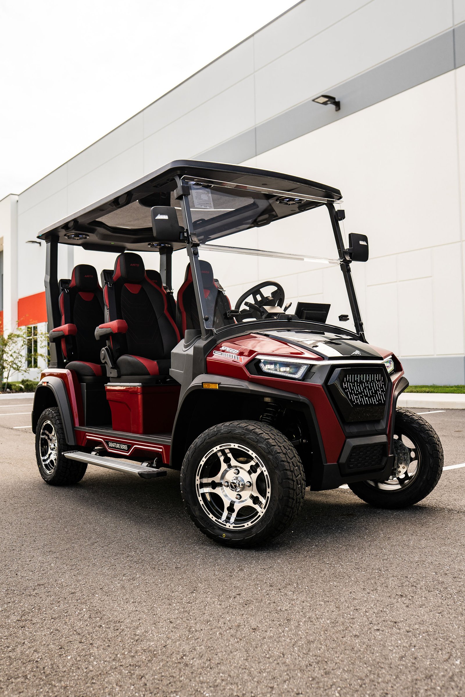 Red Aries Signature electric vehicle outside the facility